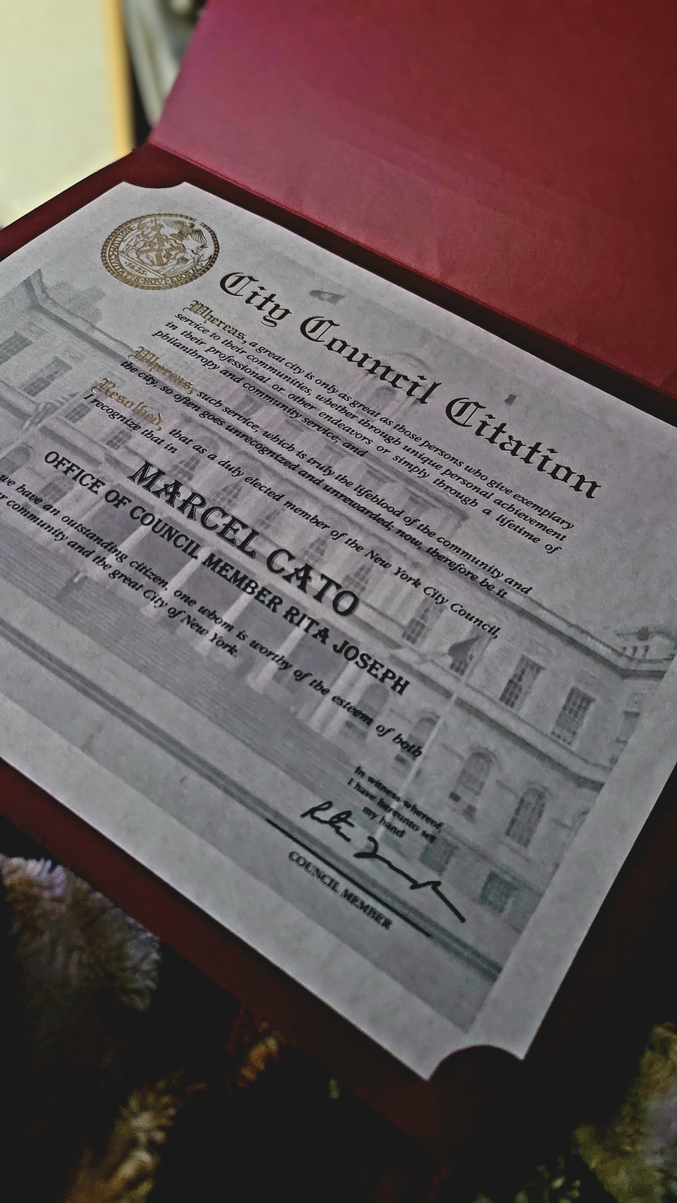 Marcel Cato holding a city hall citation